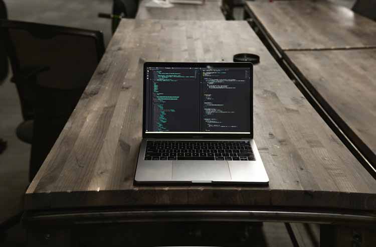 computer su tavolo con editor di codice